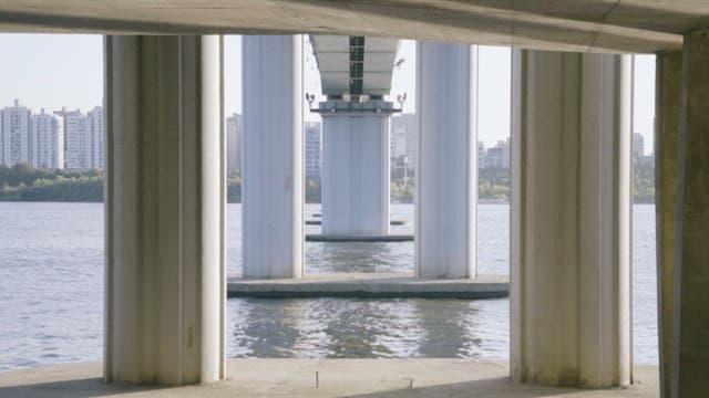 대칭적인 다리 기둥 너머로 보이는 도시 경관