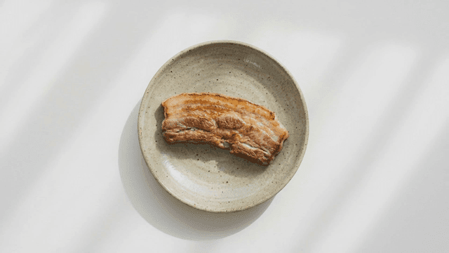Grilled pork belly on a ceramic plate