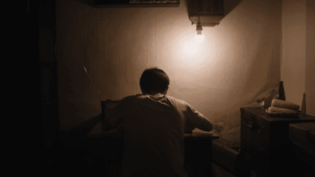 Back of student studying under dim lighting