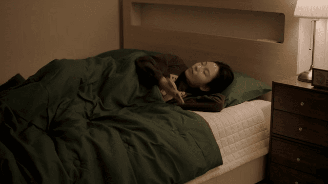 침대에 누워 스마트폰을 사용하는 여성