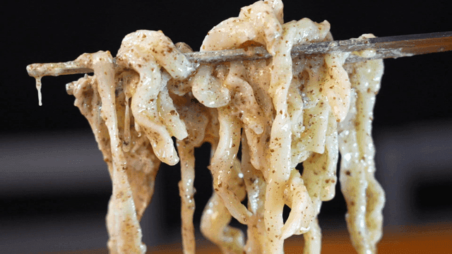 Chopsticks lifting chicken kalguksu where perilla oil and perilla seed powder mix