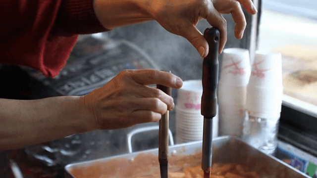 떡볶이 위에 국자를 들고있는 사람