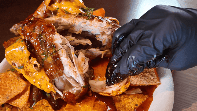 Hand dipping whole chicken in sauce