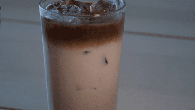 Cup of iced latte on table