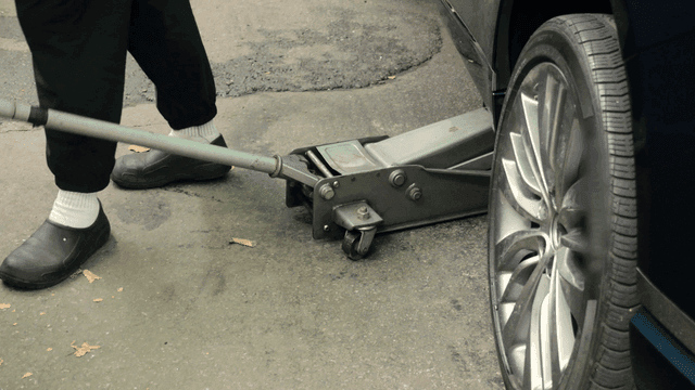 Car being lifted with a hydraulic jack