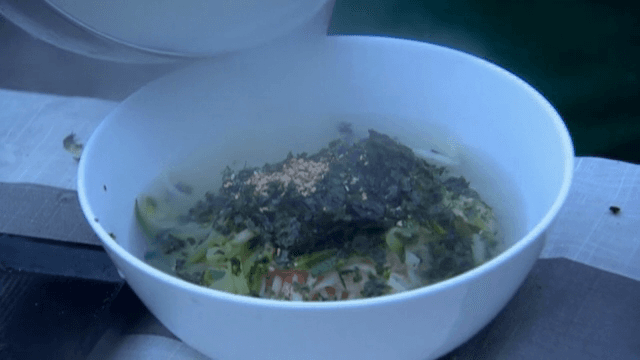 고명이 올라간 국수에 육수를 붓는 모습