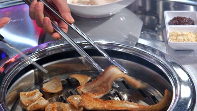 Cooked pork rinds cutting with scissors