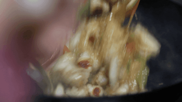 Sweet and sour pork quickly stir-fried with sauce in wok