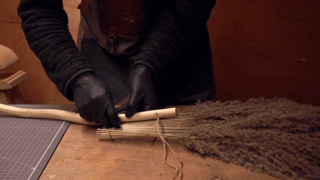 실내에서 수제 빗자루를 만드는 사람