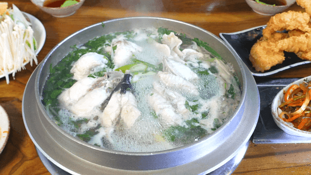 Clear pufferfish soup served with fried and seasoned side dishes
