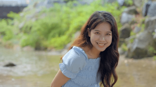 고요한 시냇가에서 미소 짓는 여성