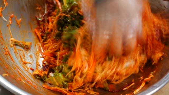 매운 소스와 채소를 섞어 만드는 비빔국수