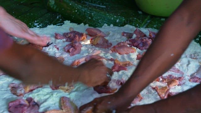 Placing fresh chicken on top of the manioc dough