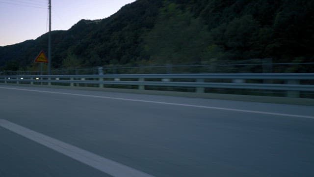 Dusk Drive Through Mountainous Road