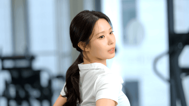Young woman stretching her lower back at gym
