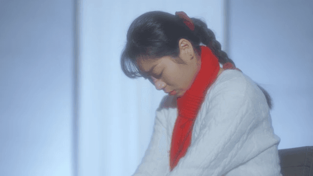 빨간 목도리를 한 여성이 생각에 잠긴 모습