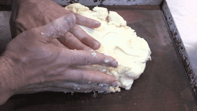 베이킹 트레이에서 반죽을 치대는 손