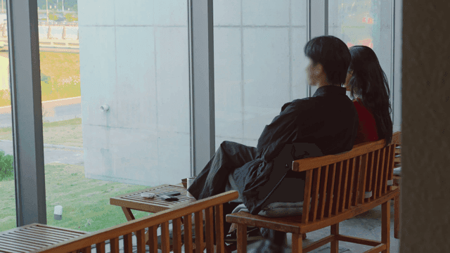 Couple sitting by a large window