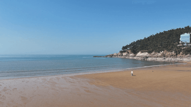 Person walking on quiet sandy beach