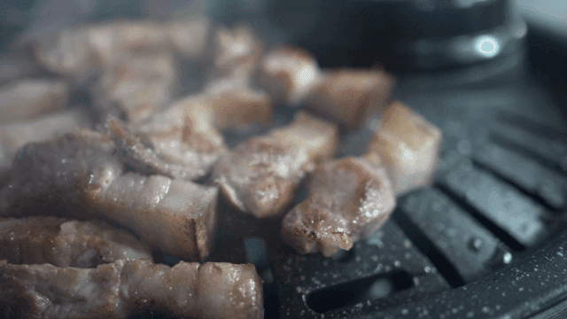 Grilling pork belly on a hot grill
