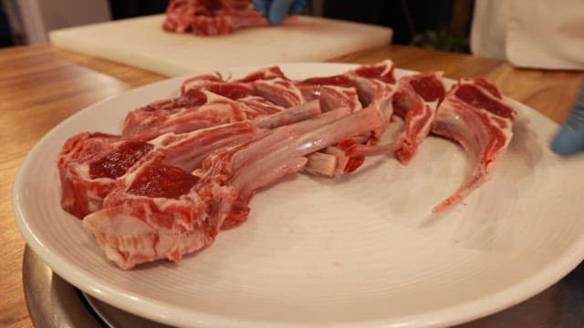 흰 접시에 신선한 양고기가 플레이팅되는 모습