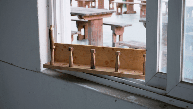 한적한 방의 창문에 놓인 나무 거치대