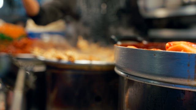 Busy Gwangjang Market street food stalls with steaming dishes