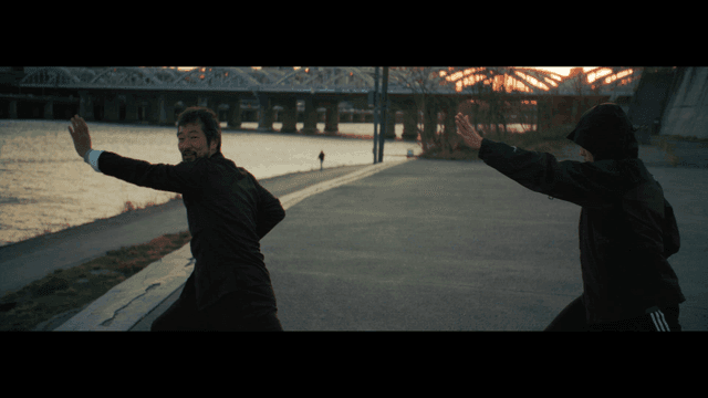 강가에서 전통 무술을 연습하는 두 사람