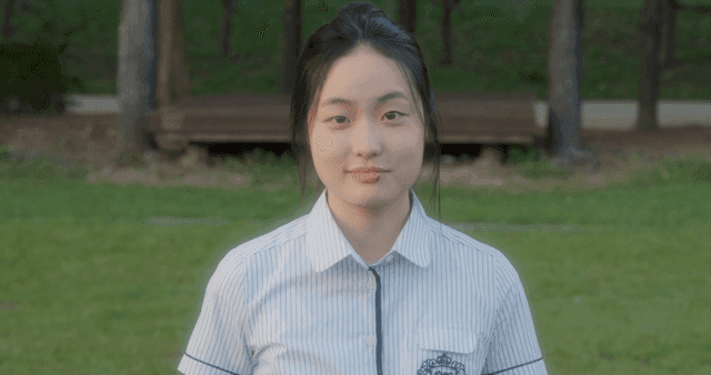 공원에서 입술에 상처가 난 채 미소 짓는 소녀