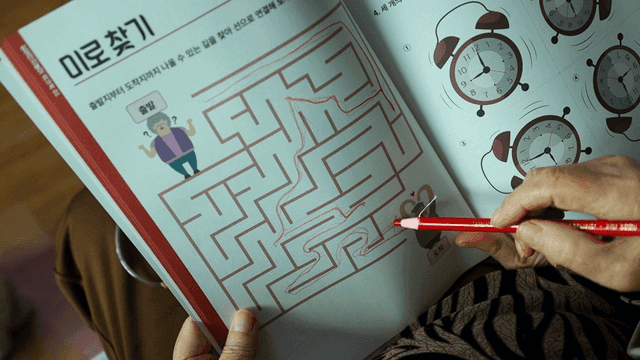 Elderly person solving a maze puzzle