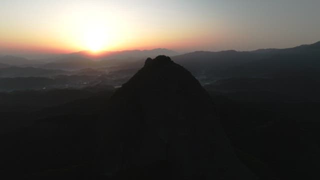 Dawning Sky and Silhouette of Majestic Mountain Peak