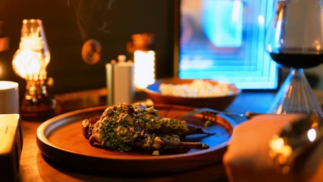 나무 테이블 위의 양고기 스테이크와 와인을 곁들인 우아한 식사