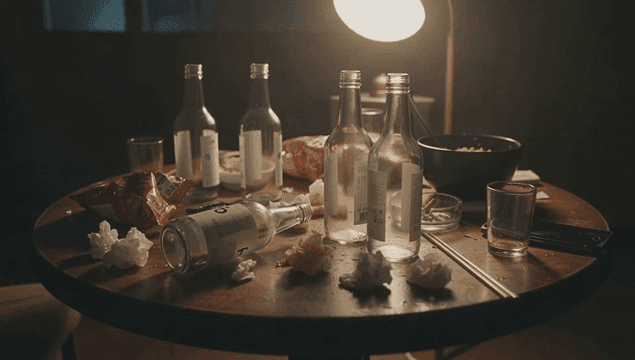 빈 소주병과 과자가 있는 어수선한 테이블