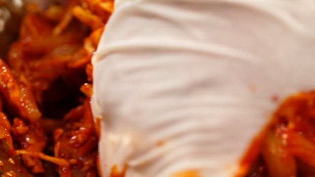 장갑 낀 손으로 한치와 양념을 버무리기