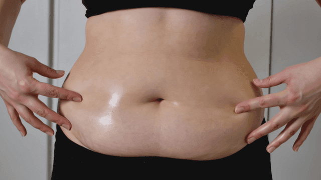 Obese woman touching her belly fat