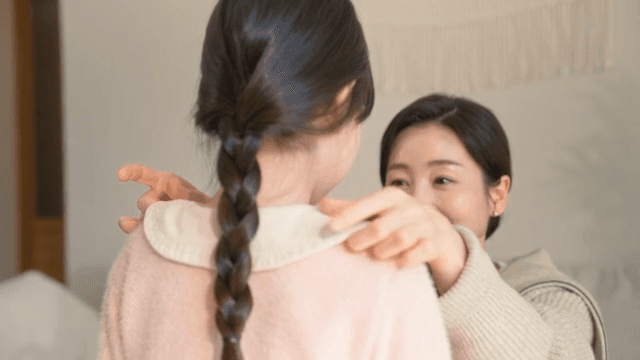 아이의 옷매무새를 정리해 주는 엄마