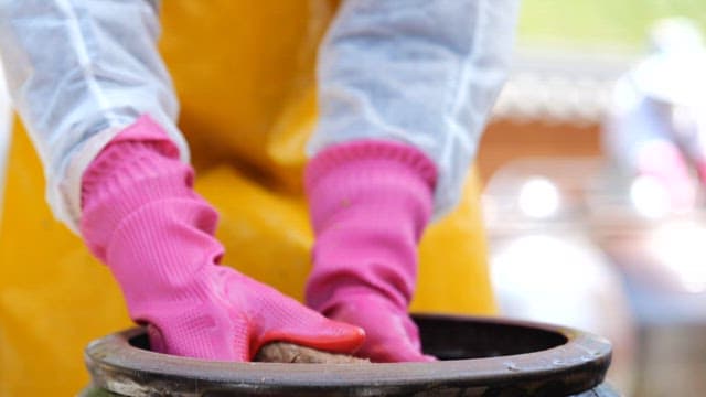 Taking out fermented soybean bricks from a crock pot