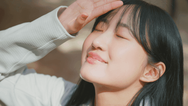 햇살을 즐기며 미소 짓는 여성