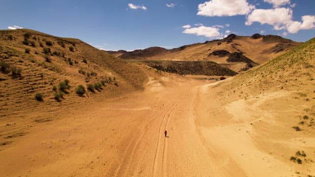 Lone Hiker Trekking Through Vast Desert