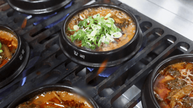 Earthen pot kimchi stew cooking on stove