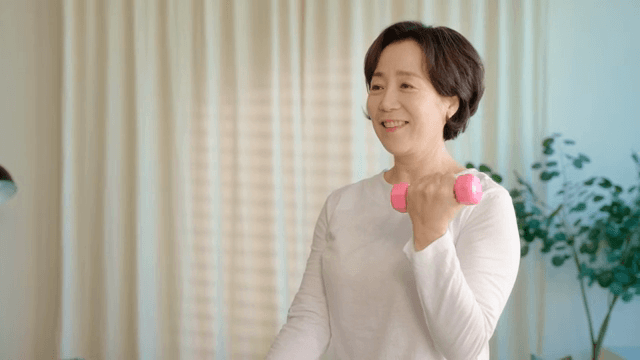 Woman exercising with dumbbells indoors