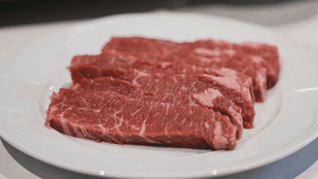 Fresh raw beef slices on a white plate