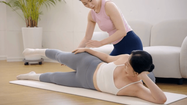 Pilates instructor guiding a student indoors