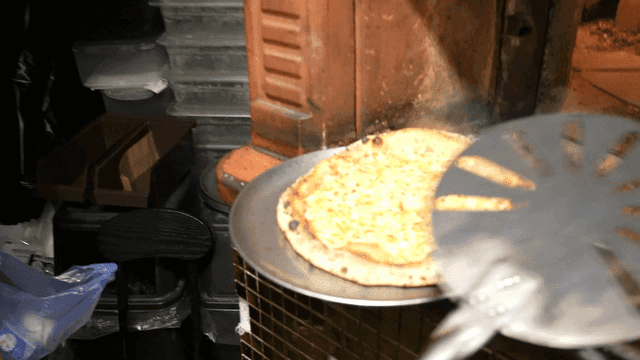 Pizza baked and taken out of wood-fired oven