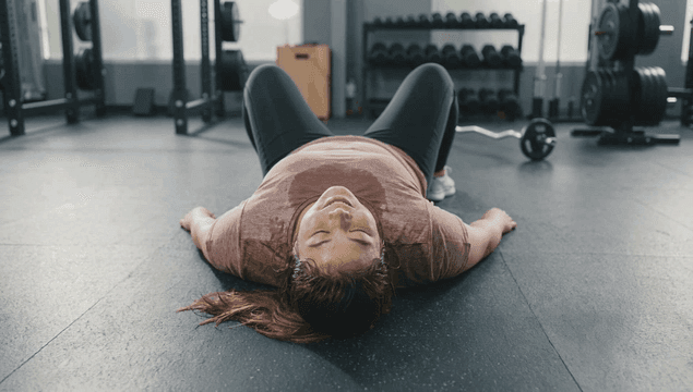 Fat woman lying on gym floor after working out