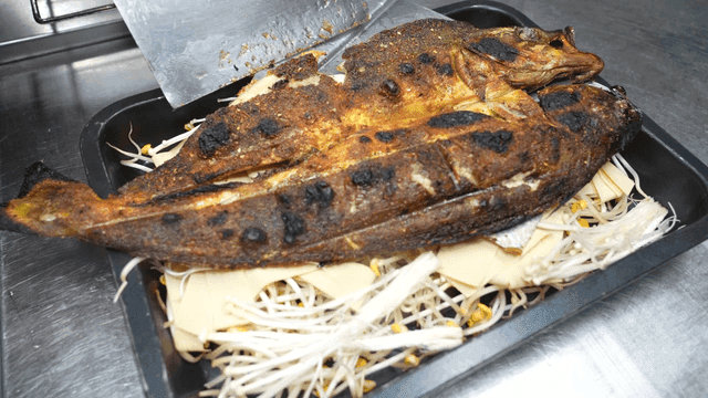 Grilled fish on a tray with vegetables