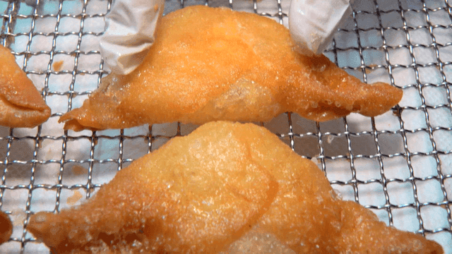 장갑을 끼고 튀긴 만두를 다루는 장면