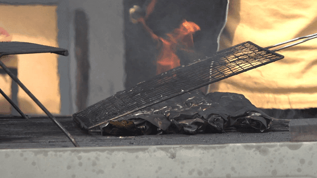 Grilling foil-wrapped fish over fire
