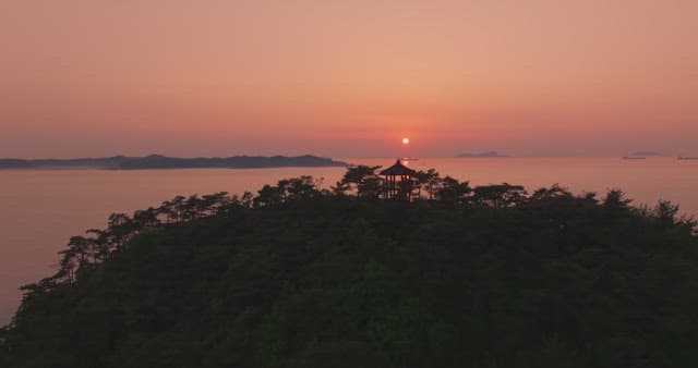 멀리 산이 보이는 고요한 바다의 일몰