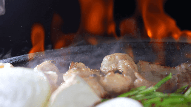 Grilled vegetables and large intestines with flames